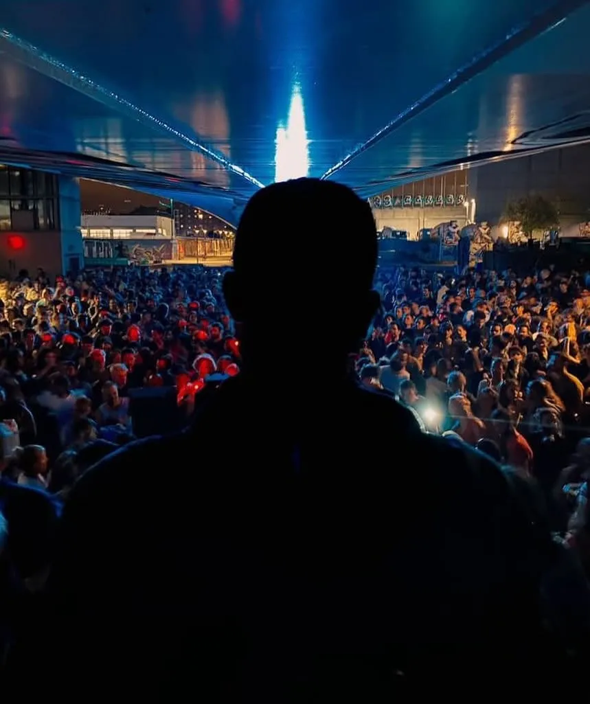 DJ face à la foule sous un plafond éclairé en bleu